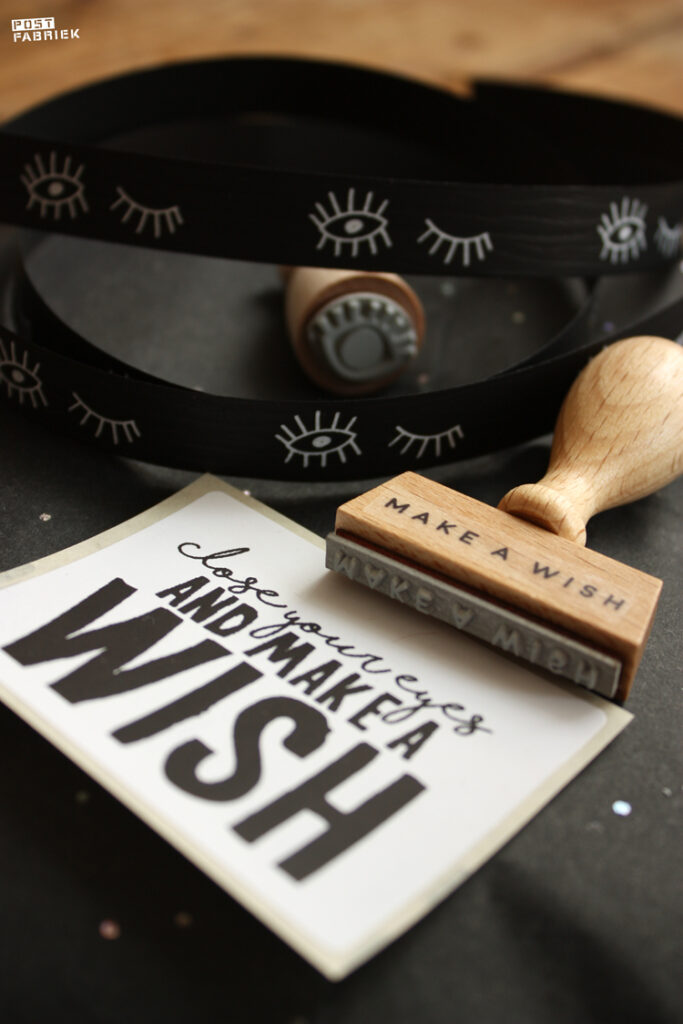 Een sticker met de tekst ‘close your eyes and make a wish’, verkrijgbaar bij Vlinders in je buik. En een stempel van Perlenfischer met de tekst ‘make a wish’.
