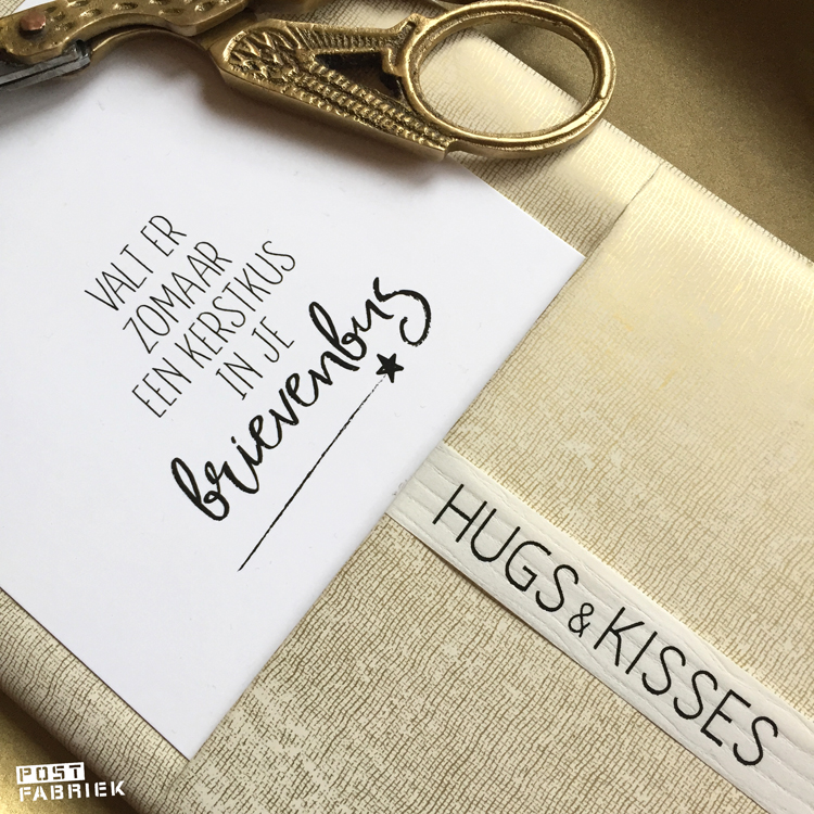 Kaartje met de tekst ‘valt er zomaar een kerstkus in je brievenbus’, papier met fabric look en lint met de tekst ‘Hugs & Kisses. Al deze producten kan je vinden bij Vlinders in je buik.