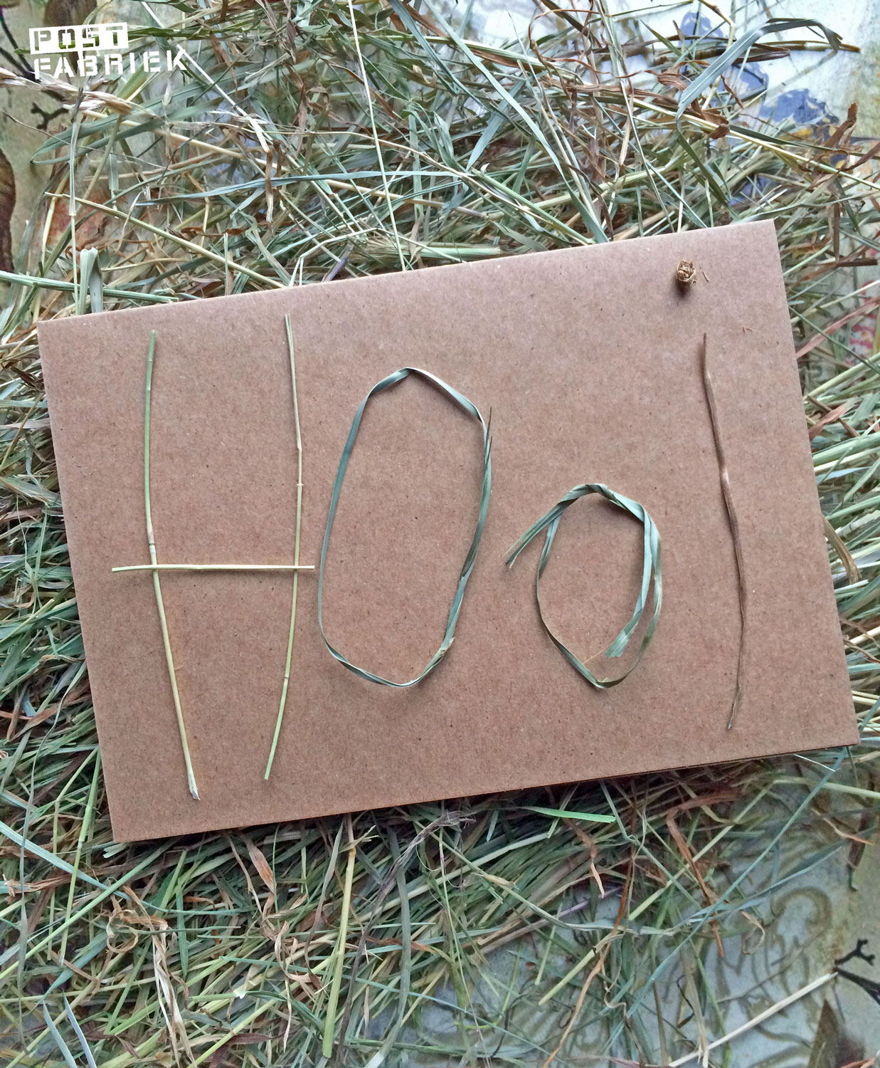 Een kaartje met letters van hooi