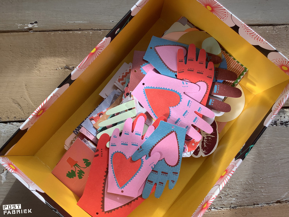 Een doos vol labels die Nienke door de jaren heen heeft verzameld. Bovenop liggen Cadeaulabels uit Flow for Paper Lovers 10, met illustraties van Louise Lockhart.